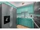 A turquoise kitchen featuring a stainless steel refrigerator and light countertops at 4140 55Th N St # 1211, Kenneth City, FL 33709