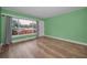 A green living room featuring hardwood floors and a large window at 4140 55Th N St # 1211, Kenneth City, FL 33709
