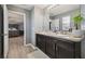 Bathroom featuring a double sink vanity and view to a bedroom with a bed at 451 Hartford Heights St, Spring Hill, FL 34609