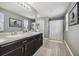 Bright bathroom featuring a double sink vanity, framed mirrors, and a shower with a white curtain at 451 Hartford Heights St, Spring Hill, FL 34609