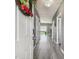 Inviting entryway with gray floors and a charming wreath on the white front door at 451 Hartford Heights St, Spring Hill, FL 34609