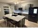 Modern kitchen featuring gray cabinets, stainless steel appliances, and a stylish island with bar seating at 451 Hartford Heights St, Spring Hill, FL 34609