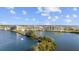 Beautiful aerial view of waterfront condos surrounded by lush greenery, a bay, and blue skies at 6009 Sea Ranch Dr # 303, Hudson, FL 34667