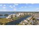 Scenic aerial shot showcasing a waterfront condo community with lush landscaping, waterways, and tennis courts at 6009 Sea Ranch Dr # 303, Hudson, FL 34667