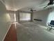 View of the spacious living room featuring ceiling fans, a front door view, and bare concrete flooring at 10814 Newbridge Dr, Riverview, FL 33579