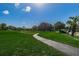 Lush green space with a winding sidewalk surrounded by mature trees, offering a tranquil and scenic environment at 1725 Pine Ridge E Way # E, Palm Harbor, FL 34684