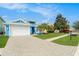 Charming blue exterior with well-manicured lawn, complemented by a paved driveway leading to a two-car garage at 6408 Key Island Ave, Apollo Beach, FL 33572
