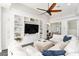 Comfortable living room boasting custom built-in shelving, a large-screen television, and a stylish ceiling fan at 6408 Key Island Ave, Apollo Beach, FL 33572