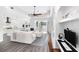 Open-concept living room with hardwood floors, sleek ceiling fan, and direct access to outdoor entertainment area at 6408 Key Island Ave, Apollo Beach, FL 33572