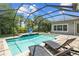 Screened-in pool featuring a waterfall, basketball hoop, and outdoor lounge chairs at 6429 Seasound Dr, Apollo Beach, FL 33572