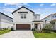 Charming two-story home featuring a brick driveway, attached garage, and manicured landscaping at 6690 Michael Favor Way, Wesley Chapel, FL 33545