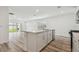 Open-concept kitchen offers an island with a sink and stainless steel dishwasher, flowing into the living area at 6690 Michael Favor Way, Wesley Chapel, FL 33545