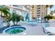 Relaxing community pool and hot tub area with lounge chairs, umbrellas, palm trees, and modern design at 1350 Gulf Blvd, Clearwater, FL 33767