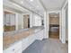 Hallway to bathroom featuring a granite counter top, large mirrors and dual access to the bathroom and closet at 1350 Gulf Blvd, Clearwater, FL 33767