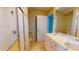 Bathroom featuring double sinks, bright lighting, a glass shower and tile flooring at 1350 Gulf Blvd, Clearwater, FL 33767