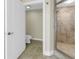 Clean bathroom featuring a tiled shower and toilet, and a white door at 1350 Gulf Blvd, Clearwater, FL 33767