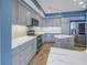 Modern kitchen with stainless steel appliances and gray cabinets, tile backsplash and marble countertops at 1350 Gulf Blvd, Clearwater, FL 33767