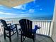 Ocean view balcony with two blue Adirondack chairs, perfect for enjoying the scenery and relaxing by the beach at 18650 Gulf Blvd # 413, Indian Shores, FL 33785