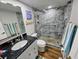 Stylish bathroom features a stone-tiled walk-in shower, elegant fixtures, and a modern vanity with granite countertop at 18650 Gulf Blvd # 413, Indian Shores, FL 33785