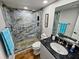 Updated bathroom with walk-in shower featuring stone accents and a glass door, alongside a modern vanity at 18650 Gulf Blvd # 413, Indian Shores, FL 33785