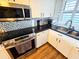 Close up on a kitchen featuring stainless steel appliances and backsplash, complementing the black granite countertops at 18650 Gulf Blvd # 413, Indian Shores, FL 33785