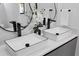 Close-up of a modern bathroom vanity with double vessel sinks and unique mirrors, accentuated by white orchids at 1905 W Erna Dr, Tampa, FL 33603