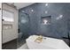 Modern bathroom showcasing the tub with a glass enclosed shower and a navy blue tiled wall at 1905 W Erna Dr, Tampa, FL 33603