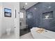 Bathroom featuring a soaking tub, glass enclosed shower with a navy blue tiled accent wall at 1905 W Erna Dr, Tampa, FL 33603