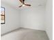 Bright, empty bedroom with a neutral color palette, tile floors, a ceiling fan, and a window at 1905 W Erna Dr, Tampa, FL 33603