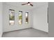 Neutral bedroom offers three large picture windows to provide natural light and a ceiling fan with a light fixture at 1905 W Erna Dr, Tampa, FL 33603