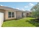 Exterior view of the back of the home with a grassy backyard and patio at 31447 Shaker Cir, Wesley Chapel, FL 33543