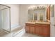Large bathroom featuring double sinks, a tub and a glass door shower at 31447 Shaker Cir, Wesley Chapel, FL 33543