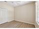 Neutral bedroom featuring a ceiling fan, wood floors, a window, and a closet at 31447 Shaker Cir, Wesley Chapel, FL 33543