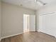 A neutral bedroom with light wood floors, closet, ceiling fan, and connected bathroom space at 31447 Shaker Cir, Wesley Chapel, FL 33543