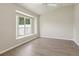 Empty bedroom featuring wood floors, a fan, and a large window seat overlooking the yard at 31447 Shaker Cir, Wesley Chapel, FL 33543