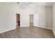 Empty bedroom with wood floors, an open doorway to the bathroom, and a ceiling fan at 31447 Shaker Cir, Wesley Chapel, FL 33543