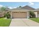 A beige two-car garage on a sunny day with green grass at 31447 Shaker Cir, Wesley Chapel, FL 33543