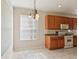 Bright eat-in kitchen featuring wood cabinets, white appliances, and tile floor at 31447 Shaker Cir, Wesley Chapel, FL 33543