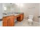 Bathroom featuring double vanities, granite counters, and ceramic tile floors at 9406 Citrus Glen Pl, Tampa, FL 33618