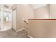 Carpeted hallway with stairs, wood railing and access to the upper level at 9406 Citrus Glen Pl, Tampa, FL 33618