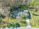 Aerial view of a well-maintained home featuring a long driveway and surrounded by a white picket fence at 11201 Knotty Pine Dr, New Port Richey, FL 34654