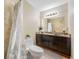 Cozy bathroom featuring a toilet, vanity with granite countertop, and tiled shower at 11201 Knotty Pine Dr, New Port Richey, FL 34654