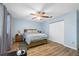 This bedroom has a wood bed frame, ceiling fan, closet, and wood-look flooring at 11201 Knotty Pine Dr, New Port Richey, FL 34654