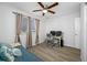 Bright bedroom featuring a futon, desk, windows, and a modern ceiling fan at 11201 Knotty Pine Dr, New Port Richey, FL 34654
