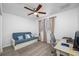 Bright bedroom featuring a futon, desk, windows, and a modern ceiling fan at 11201 Knotty Pine Dr, New Port Richey, FL 34654