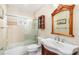 Bathroom featuring a vanity with sink, wooden framed mirror, and tiled shower with sliding glass door at 1600 Gray Bark Dr, Oldsmar, FL 34677