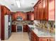 Spacious kitchen featuring granite countertops, stainless appliances, tile backsplash, and wood cabinets at 1600 Gray Bark Dr, Oldsmar, FL 34677