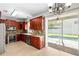 Open kitchen with stainless appliances, custom wood cabinets and access to screened-in pool at 1600 Gray Bark Dr, Oldsmar, FL 34677