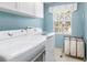 Laundry room with modern washer and dryer, bright window, and overhead storage at 1600 Gray Bark Dr, Oldsmar, FL 34677