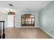 Bright living room featuring hardwood floors, a custom window, and arched door frame at 1600 Gray Bark Dr, Oldsmar, FL 34677